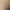 Une femme en robe de bain blanche est assise à une table dans un salon de beauté, les mains jointes, tandis qu'une autre personne est penchée vers elle