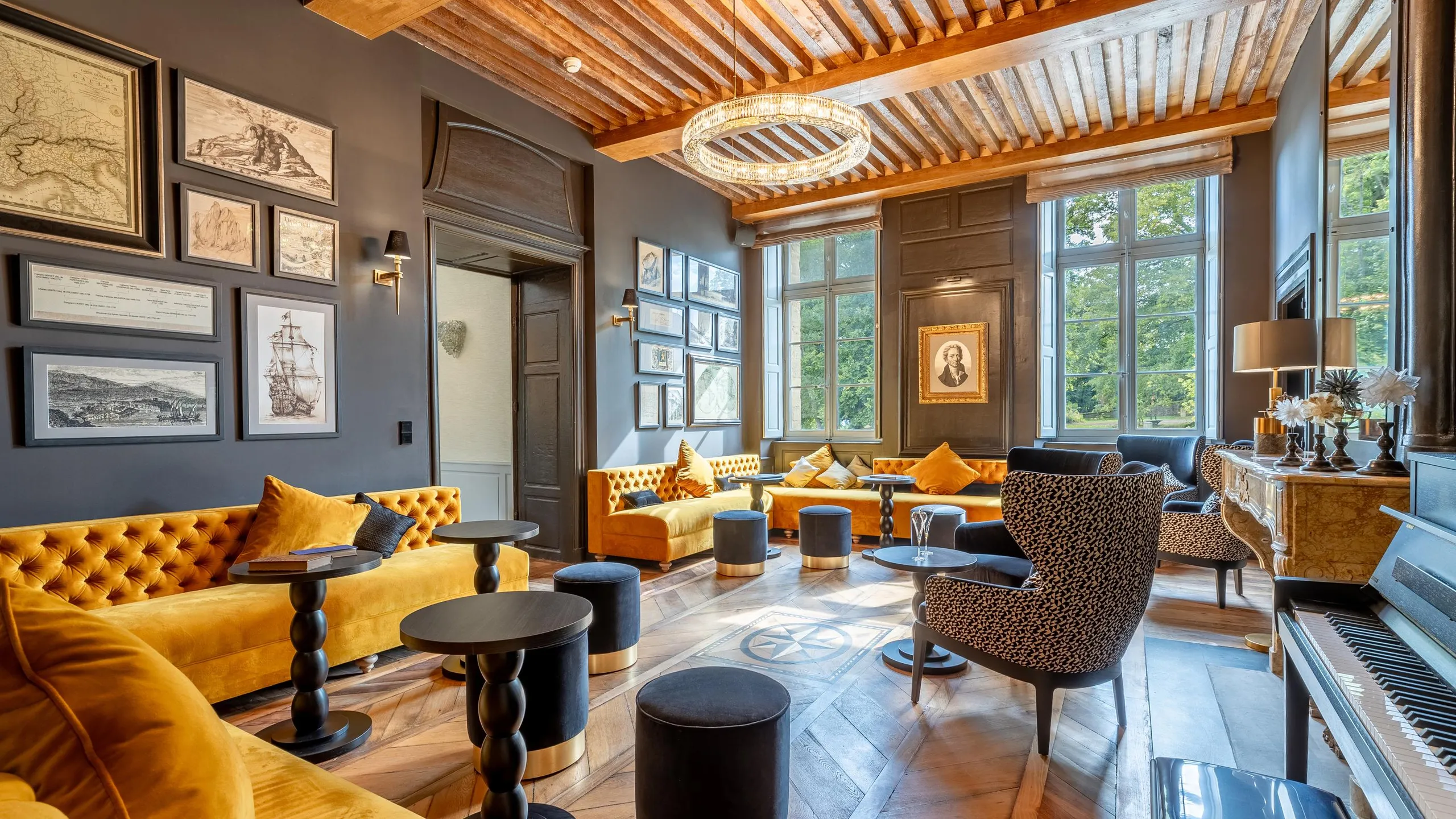 Salon élégant avec canapés jaunes, fauteuils à motifs, tables basses et grandes fenêtres laissant entrer la lumière naturelle